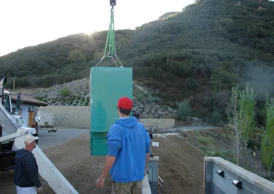 A man lifting a green box onto a truck.